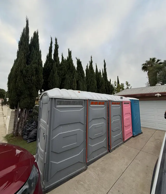 Portable toilets lined up on a private home driveway