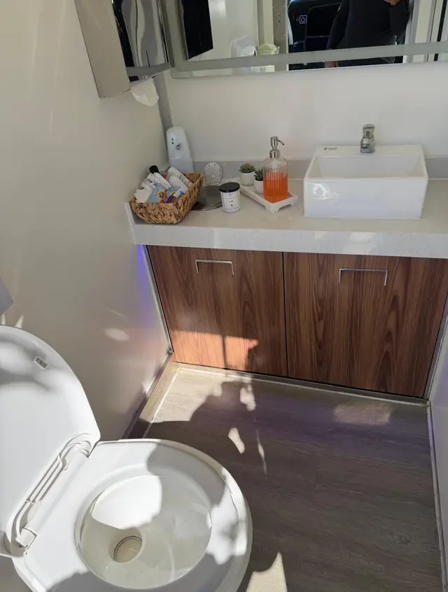 Restroom trailer vanity with sink, soap, lotion and toilet