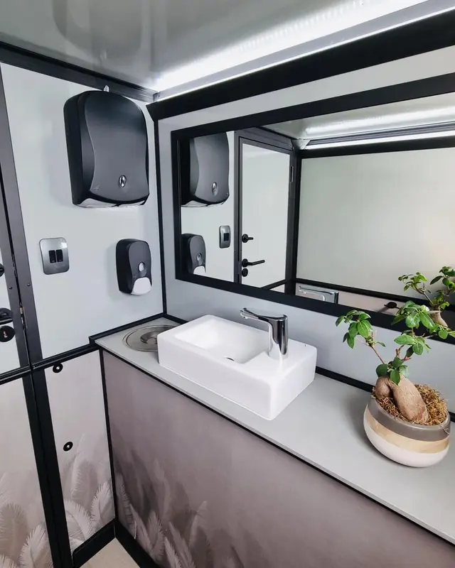 Restroom trailer vanity with vessel sink, mirror and towel dispenser